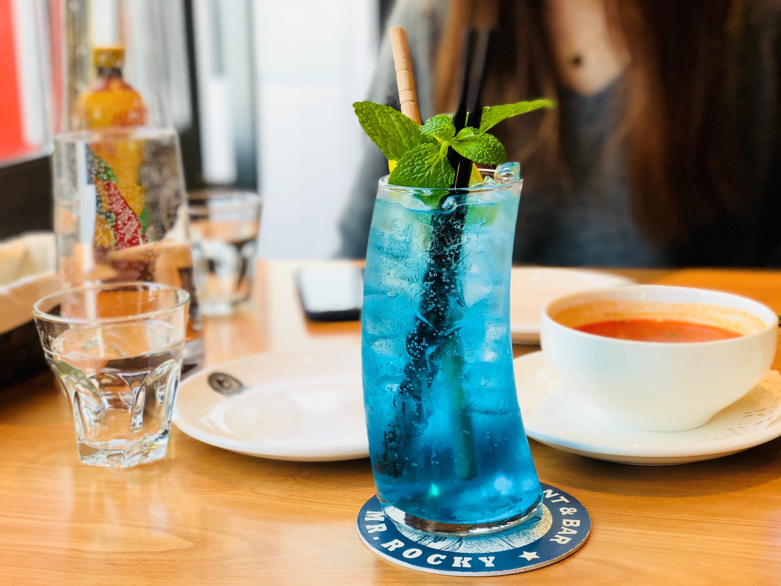 bEight Reasons You Should Be Growing Your Own Herbs lue cocktail drink with mint on table